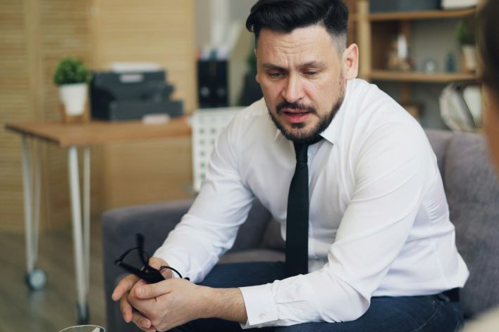 Psychotherapist in conversation with client, addressing emotional concerns in a calm office setting.